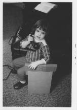 author as a young girl holding an old-fashioned telephone receiver